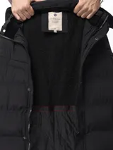 Campera de nylon acolchada en color azul marino, con cierre frontal y botones a presión, bolsillos laterales y capucha desmontable.
