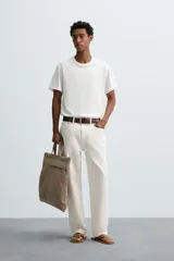 Camiseta de algodón de peso medio, color gris oscuro con efecto lavado ligero. Presenta cuello redondo y manga corta.