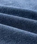 Campera de jean azul para hombre, con efecto desteñido, cuello inglés, cierre frontal de botones metálicos y bolsillos frontales con solapa.