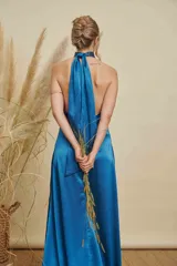Vestido largo de satén color azul, con cuello halter alto y tajo lateral profundo en la falda.