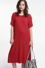 Vestido midi color beige, de corte oversized, con cuello redondo, manga corta y tajos laterales. Presenta un parche decorativo en la manga.