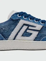 Championes Balmain modelo Swan, confeccionados en denim con efecto desgastado. Presentan el logo de la marca en el lateral en color blanco, cordones azules y suela de goma blanca.