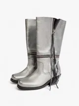 Bota de cuero plateado con caña media, cierre de cremallera lateral y detalle de flecos.