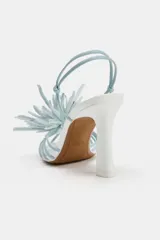 Sandalias de tacón alto y ancho, color blanco con tiras y detalle de flor decorativa en la parte delantera en tono celeste.