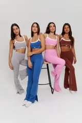 Conjunto deportivo compuesto por un top de escote redondo con breteles blancos y un pantalón largo de corte acampanado, ambos en color gris melange.