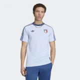 Remera Adidas de la colección Originals inspirada en la selección de Italia. Es de color celeste claro con cuello redondo y mangas cortas, presenta las tres tiras características de la marca en azul sobre los hombros y mangas. Incluye el logo del Trifolio de Adidas en el lado derecho del pecho y el escudo de la selección italiana en el lado izquierdo.
