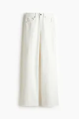 Jean de tiro alto con corte wide leg, confeccionado en denim rígido de color blanco. Presenta diseño clásico de cinco bolsillos, cierre frontal con botón y ruedo con terminación desflecada.