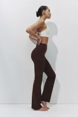 Leggings deportivos acampanados de color marrón, tiro alto y diseño ajustado con perneras amplias hacia el dobladillo.