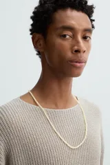 Collar de longitud media compuesto por pequeñas cuentas o abalorios de piedras combinadas en tonos claros y neutros.