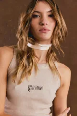 Musculosa de morley color gris con textura acanalada, cuello redondo, sin mangas y pequeño estampado tipográfico en el pecho.