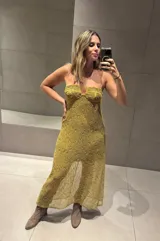 Vestido largo de tejido abierto color mostaza con forro corto, escote pronunciado en V y tirantes finos.