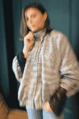 Campera bomber oversize de paño italiano con estampado en zigzag blanco y negro, cuello alto y cierre frontal con broches a presión. Tiene mangas murciélago.