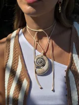 Gargantilla de tiento color beige con dije de caracol de resina.