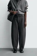 Pantalón de corte balloon fit, color negro, con bolsillos laterales de vivo y bolsillos traseros con solapa. Presenta cierre frontal con cremallera y botón.
