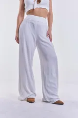 Pantalón blanco de corte palazzo con cintura alta y elástica.