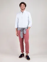 Camisa de hombre oxford con diseño de rayas verticales celestes y blancas, corte regular fit, cuello button-down, manga larga y cierre frontal con botones.