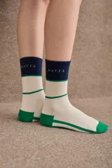 Medias de caña media con diseño tricolor en blanco, verde y azul marino. Presentan el logo de la marca bordado en la parte superior y puntera y talón reforzados en color verde.