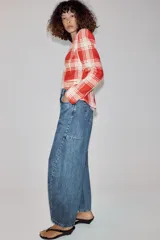 Jeans balloon leg de tiro medio y longitud al tobillo, con efecto lavado, cintura con trabillas, cinco bolsillos y cierre frontal con cremallera y botón.