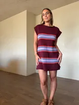 Vestido corto de punto de algodón color bordó, con diseño de rayas horizontales en tonos celestes y rojos, silueta recta y cuello redondo sin mangas.