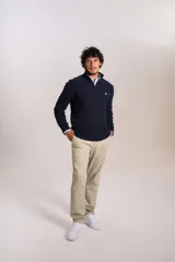Sweater de punto acanalado color azul marino, con cuello alto y cierre frontal parcial. Presenta el logo de la marca bordado en el pecho y puños con terminación elástica.