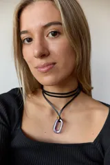 Collar con tiento negro y dije de piedra natural ovalada en tonos grises y azules.