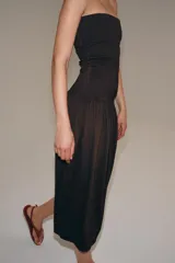 Vestido midi de corte bandeau con escote palabra de honor y detalle de vuelta en el pecho. Presenta una cintura entallada con pliegues y una falda con volumen en tejido combinado a tono.