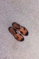 Sandalia de diseño minimalista con tiras anchas de neopreno color tostado, plantilla acolchada y base de goma antideslizante con costuras a la vista.