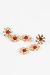 Caravanas largas colgantes con diseño de tres flores en metal plateado, cada una con una piedra verde brillante en el centro.