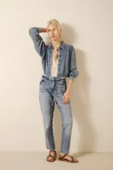 Jean de corte mom fit, tiro medio-alto y calce holgado, con pierna recta que ajusta hacia el ruedo. Confeccionado en denim azul con un lavado claro, localizado, con bigotes. En los bolsillos traseros lleva un bordado de alas.