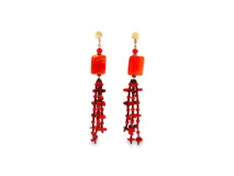 Caravanas largas con base circular dorada, cuenta roja, pieza rectangular de resina en color rojo anaranjado y cascada de cuentas y fragmentos rojos colgantes.