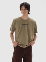 Remera de algodón con efecto lavado, cuello redondo y mangas cortas. Presenta un estampado gráfico en el centro del pecho con la inscripción 'Les Enfants Deprime'.