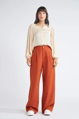 Pantalón de vestir color óxido con corte oxford, cintura con elástico, cierre frontal con botón y bolsillos laterales.