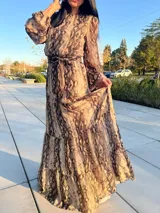 Vestido largo de animal print con cuello redondo, mangas largas abullonadas y falda escalonada.