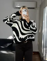 Sweater de tejido de punto con diseño de ondas en color marrón y crema, de cuello redondo y manga larga.