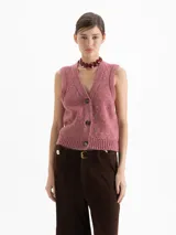 Chaleco de punto con escote en V y cierre frontal de botones. Presenta un diseño en color rosa con sutiles destellos metalizados y terminaciones en ribb elástico en sisa y cintura.