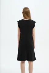 Vestido midi de poliéster color blanco, de corte recto y escote redondo a la base, con mangas cortas abuchonadas con volados y detalles de volados en el ruedo.