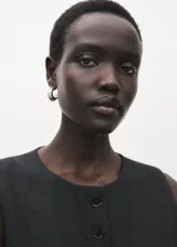 Chaleco de estilo sastre en color negro, con cuello redondo, cierre frontal de botones y diseño recto sin mangas.