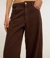 Pantalón de corte recto y estilo loose, confeccionado en sarga de algodón. Presenta cintura con trabillas, cierre frontal con botón y cremallera, y bolsillos funcionales tanto en la parte delantera como en la trasera.