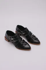 Sandalias bajas de cuero color dorado con tiras entrecruzadas y hebillas ajustables. Taco de madera.