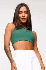 Top deportivo negro, estilo crop top, con cuello polo y escote en V. Presenta tirantes anchos y corte ajustado al cuerpo.