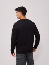 Sweater color arena con logo Rusty estampado en el pecho, de corte regular fit.