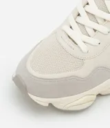 Championes estilo dad sneaker de la marca Viko, confeccionados en poliuretano con diseño de recortes y suela alta. Presentan cierre mediante cordones y detalles en los laterales.