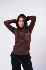 Campera de felpa con frisa y lycra color bordó, con capucha, cierre metálico y bolsillos frontales.