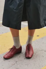 Zapatos chatos de cuero color bordó, con cordones finos y punta cuadrada.