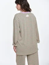 Remera de dormir de corte oversize con estampado de rayas horizontales, confeccionada en algodón con elastano. Presenta cuello redondo en rib de color rojo contrastante y mangas largas.