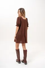 Vestido corto marrón con escote cuadrado, mangas cortas abullonadas con elástico y corte recto.