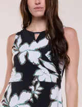 Vestido maxi sin mangas de seda fría, color negro con estampado floral blanco y verde. Presenta escote cruzado con detalle de abertura y corte en la cintura con falda amplia.