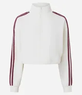 Campera deportiva color blanco hueso, con textura de malla waffle, cuello alto y cierre frontal. Presenta dos franjas verticales de color bordó en las mangas.