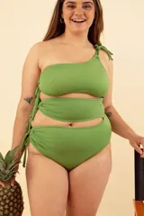 Malla enteriza verde con diseño asimétrico de un solo hombro y cortes en la cintura con lazos laterales.