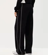 Pantalón de corte recto color negro con tiras laterales blancas en contraste. Cuenta con cintura elástica y cordón ajustable.